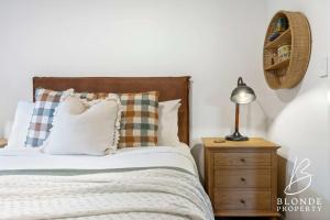 a bedroom with a bed and a lamp on a night stand at Journeyman's Cottage in Ballarat