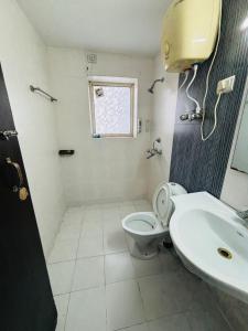 a bathroom with a toilet and a sink at Luxury & Peaceful stay in Omaxe in Vrindāvan