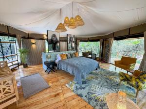 ein Schlafzimmer mit Bett und ein Wohnzimmer in der Unterkunft Olkinyei Mara Tented Camp in Talek