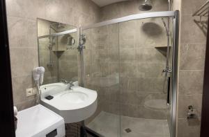 un bagno con lavandino e doccia in vetro di Crystal Loft a Bakuriani