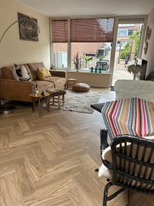 a living room with a couch and wooden floors at Beachhouse Wijk aan Zee! in Wijk aan Zee