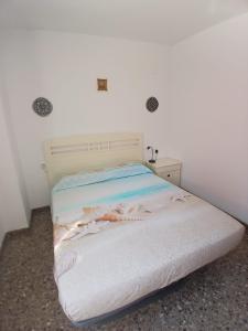 a bedroom with a bed with a white bedspread at Tikitita House in Gandía +7 photos