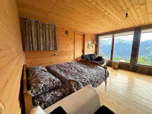 una camera da letto con un letto grande in una stanza con le montagne di Heshkili huts and cabins Svaneti a Keshkili