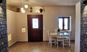 a dining room with a table and chairs and a door at Dimitras house palaiopoli in Kythira +15 photos