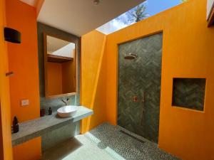 an orange bathroom with a sink and a shower at Marshmallow Bay Boutique Hotel & Surf Point Adults Only in Ahangama