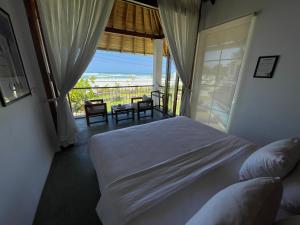a bedroom with a bed and a view of the ocean at Marshmallow Bay Boutique Hotel & Surf Point Adults Only in Ahangama