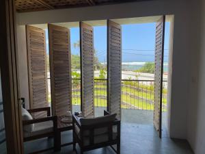 a room with doors open to a balcony with a view at Marshmallow Bay Boutique Hotel & Surf Point Adults Only in Ahangama