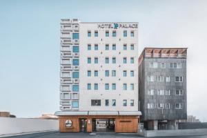 庆州Hotel Palace Gyeongju的一座高大的白色建筑,毗邻一座建筑