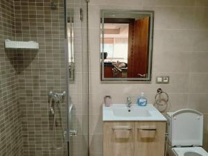 een badkamer met douche, wastafel en toilet bij Appartement vue sur mer, terrasse ensoleillée in Asilah