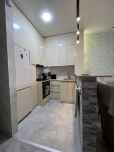 ItʼkhvisiDS & Sea Suites Batumi的厨房配有白色橱柜和瓷砖地板