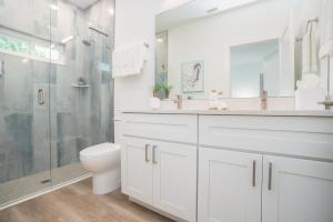 Un baño blanco con ducha y WC. en Sun Seekers Beach House- Steps from Butler Beach, en St. Augustine 113 fotos más