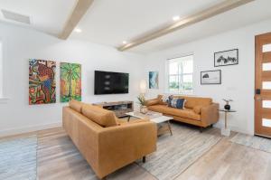 Una sala de estar con dos sofás y un televisor. en Sun Seekers Beach House- Steps from Butler Beach, en St. Augustine