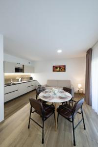 a kitchen and living room with a table and chairs at Villa Betty Apartments in Arco
