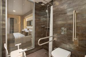 a bathroom with a shower with a toilet and a sink at Limak Eurasia Luxury Hotel in Istanbul
