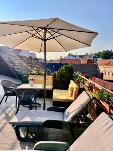 a patio with an umbrella and tables and chairs at Rooftop Central Apartment in Braşov