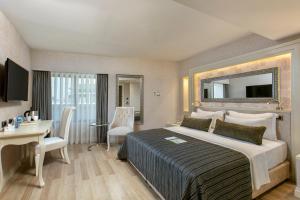 a hotel room with a large bed and a desk at Limak Eurasia Luxury Hotel in Istanbul