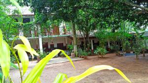 um edifício com árvores e plantas na frente em Prasanna Hotel and Rest em Habarana