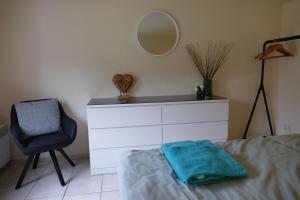 une chambre avec un lit, un miroir et une chaise dans l'établissement Ferienhaus Frida, à Samtens 11 autres photos