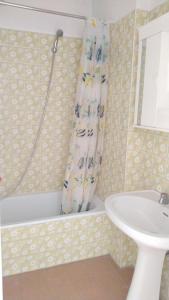 a bathroom with a tub and a sink and a shower curtain at La Casa Blu a Montalto Marina in Torre di Montalto