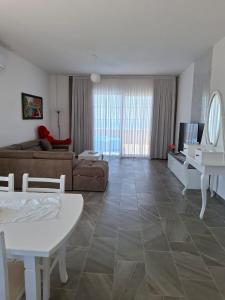 een woonkamer met een bank en een tafel bij Ada’s house in Durrës