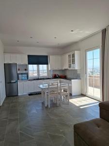 een keuken met witte kasten en een tafel en stoelen bij Ada’s house in Durrës