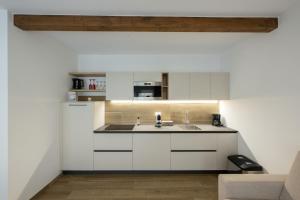 a kitchen with white cabinets and a sink at Villa Betty Apartments in Arco