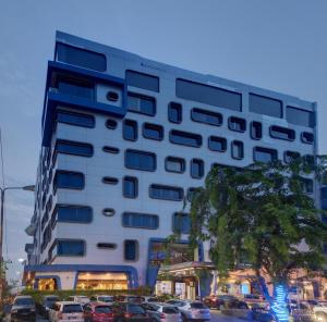 een hoog gebouw met auto's geparkeerd op een parkeerplaats bij Karibia Boutique Hotel in Medan