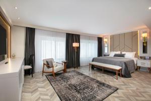 a hotel room with a bed and a couch and chair at Limak Eurasia Luxury Hotel in Istanbul