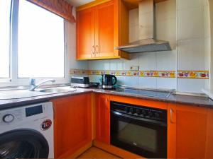 a kitchen with orange cabinets and a washer and dryer at Banana Beach in Marbella