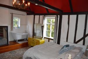 a bedroom with a bed and a tub and a sink at Countryside Tiny House in Roydon +37 photos