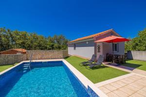 LinardićiにあるHoliday Home Boroのテーブルと赤い傘付きのスイミングプール