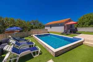 LinardićiにあるHoliday Home Boroの椅子とパラソルのあるプール