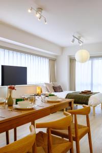 un salon avec une table et un lit dans l'établissement パレグレイス - Palaisgrace Shibuya, à Tokyo