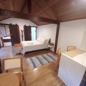 a bedroom with a bed and a table and chairs at Chalé Canarinho in São Pedro da Serra