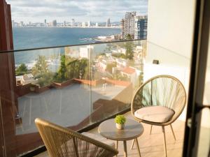 マサトランにあるSunset Mazatlán • Rooftop Pool Breathtaking Viewの海の景色を望むバルコニー(椅子、テーブル付)