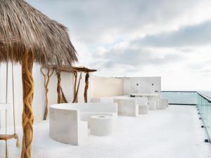 マサトランにあるSunset Mazatlán • Rooftop Pool Breathtaking Viewの白いテーブルと藁の傘が置かれたパビリオン