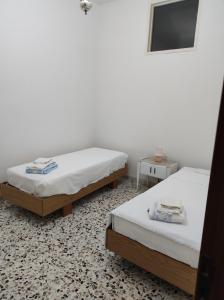 a room with two beds and a tv at Sognando Ostuni in Ostuni