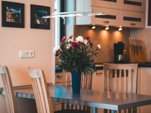 a dining room table with a vase of flowers on it at Villa Friede-Marie, Ostseeweitblick in Sassnitz +18 photos