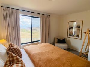 une chambre avec un lit et une grande fenêtre dans l'établissement Oak Vue cottage, à Korumburra