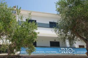 a white building with trees in front of it at Tramonto Suite in Novalja
