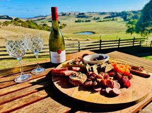une assiette de nourriture et une bouteille de vin sur une table dans l'établissement Oak Vue cottage, à Korumburra