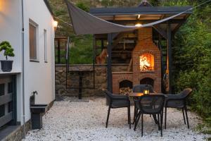 a patio with a table and chairs and a fireplace at Nature Loft in Porumbacu de Sus