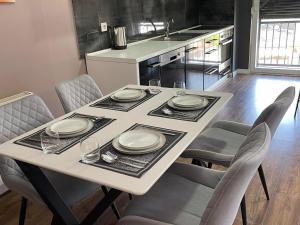 a table with plates and glasses on it in a kitchen at J K E apartments in Prishtinë