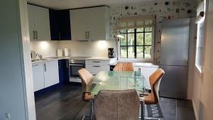a kitchen with a glass table and chairs at Haus Zauberblau in Poseritz