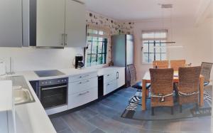 a kitchen with white cabinets and a table and chairs at Haus Zauberblau in Poseritz