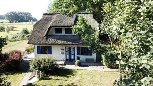 a blue and white house with a thatched roof at Haus Zauberblau in Poseritz