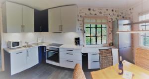 a kitchen with white cabinets and a wooden table at Haus Zauberblau in Poseritz +28 photos