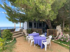 a group of tables and chairs in front of a house at ECO Beach Houses - Pet friendly in Peroj