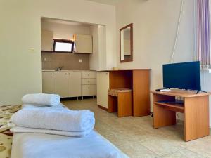 Una habitación con un escritorio con dos toallas sobre una cama. en Къща за Гости Чайка, en Byala