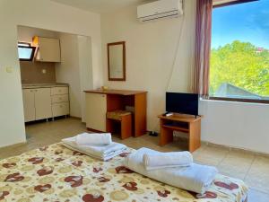Habitación con 2 camas, escritorio y ventana. en Къща за Гости Чайка, en Byala